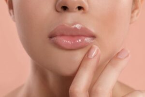 Close-up of full, glossy lips with a natural shape, illustrating the effects of lip augmentation treatments.