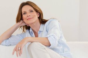 Relaxed middle-aged woman with mild cheek hollowness, representing facial changes linked to Ozempic face.