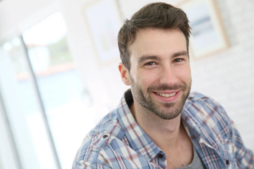 Smiling man with healthy hair and clear skin, representing ideal candidate for Ariessence rejuvenation treatment