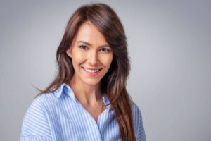 Confident woman with smooth facial features after deep plane facelift, showcasing natural rejuvenation results.