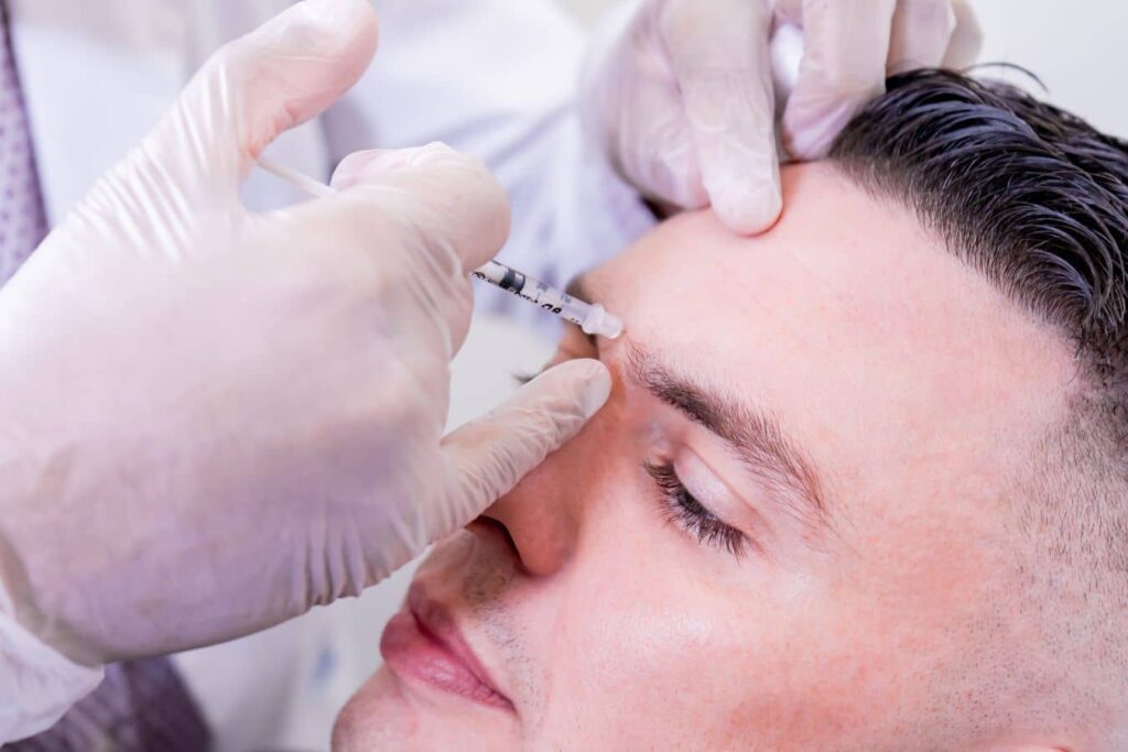 Practitioner administering Botox injection to forehead, targeting dynamic wrinkles and common facial treatment areas