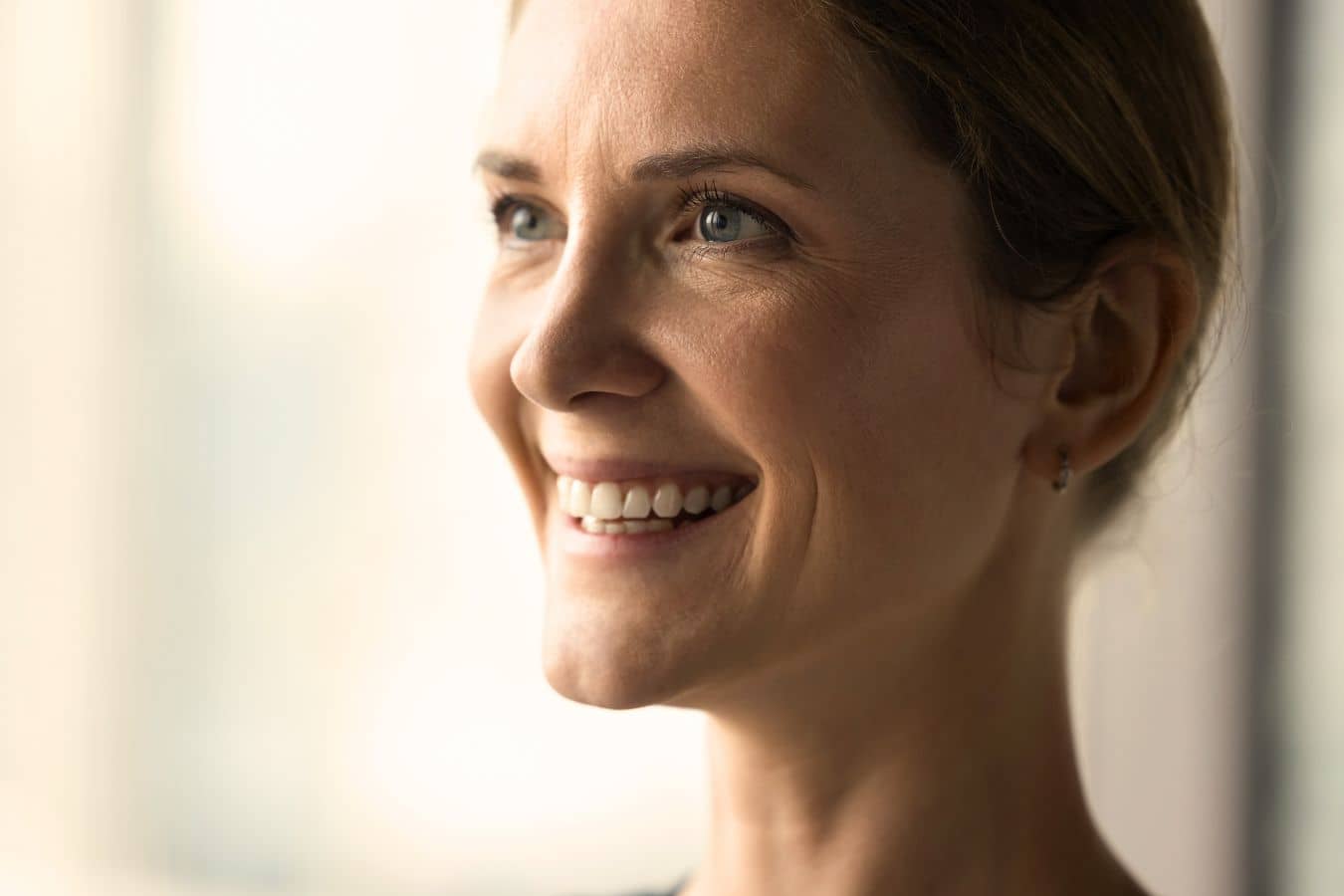 Woman smiling with smooth skin, illustrating results of Botox vs Dysport for reducing facial wrinkles and rejuvenation