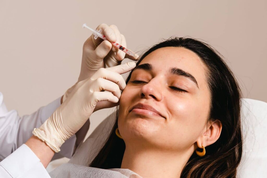 Practitioner injecting forehead to compare Botox vs Dysport results, showing wrinkle treatment and facial muscle relaxation