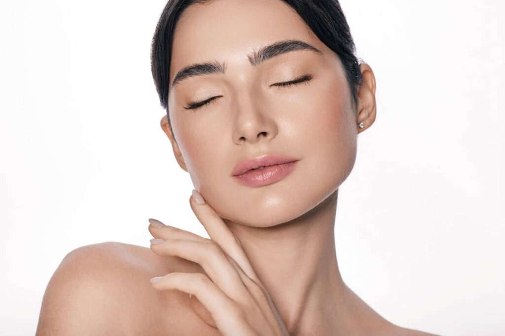 Woman with smooth skin representing dermal fillers in your 20s for lip enhancement and preventative facial rejuvenation.